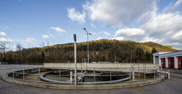 The picture shows a round concrete / steel structure with railing placed on the ground at the site of the sewage treatment plant.