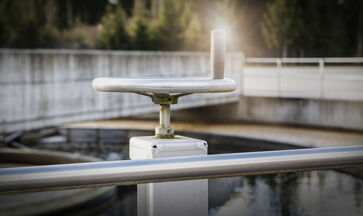 The picture shows a round concrete / steel structure with railing placed on the ground at the site of the sewage treatment plant.