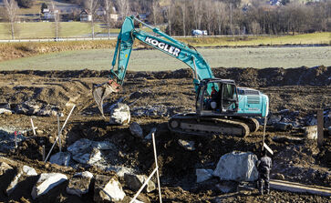 The picture shows a large construction site with heavy equipment in the field.